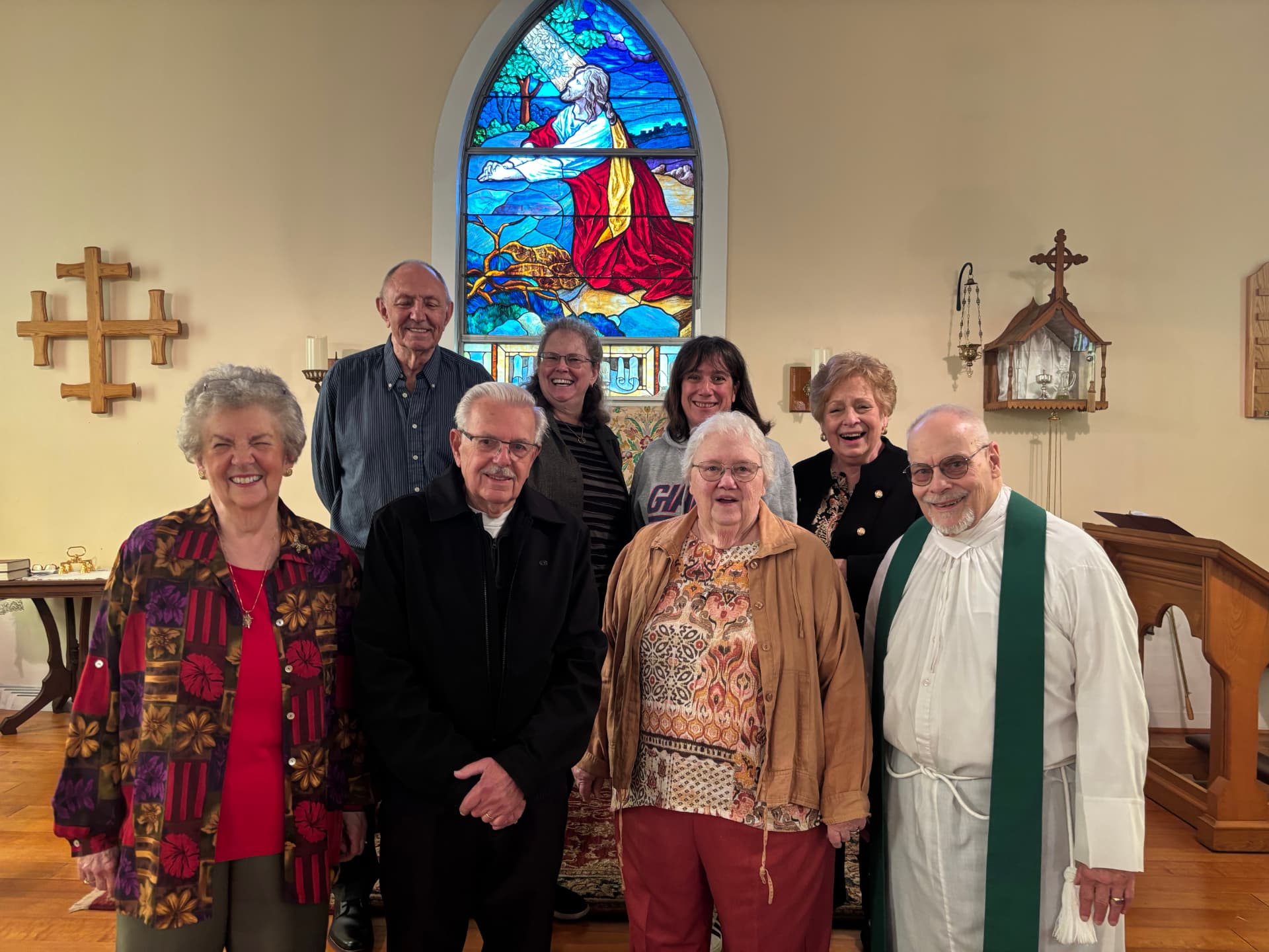 The Vestry of St. John's with Fr. Miller in front of the stained glass window